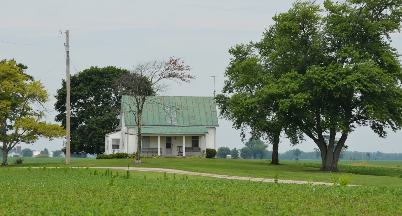 A white house sits among lush green fields.